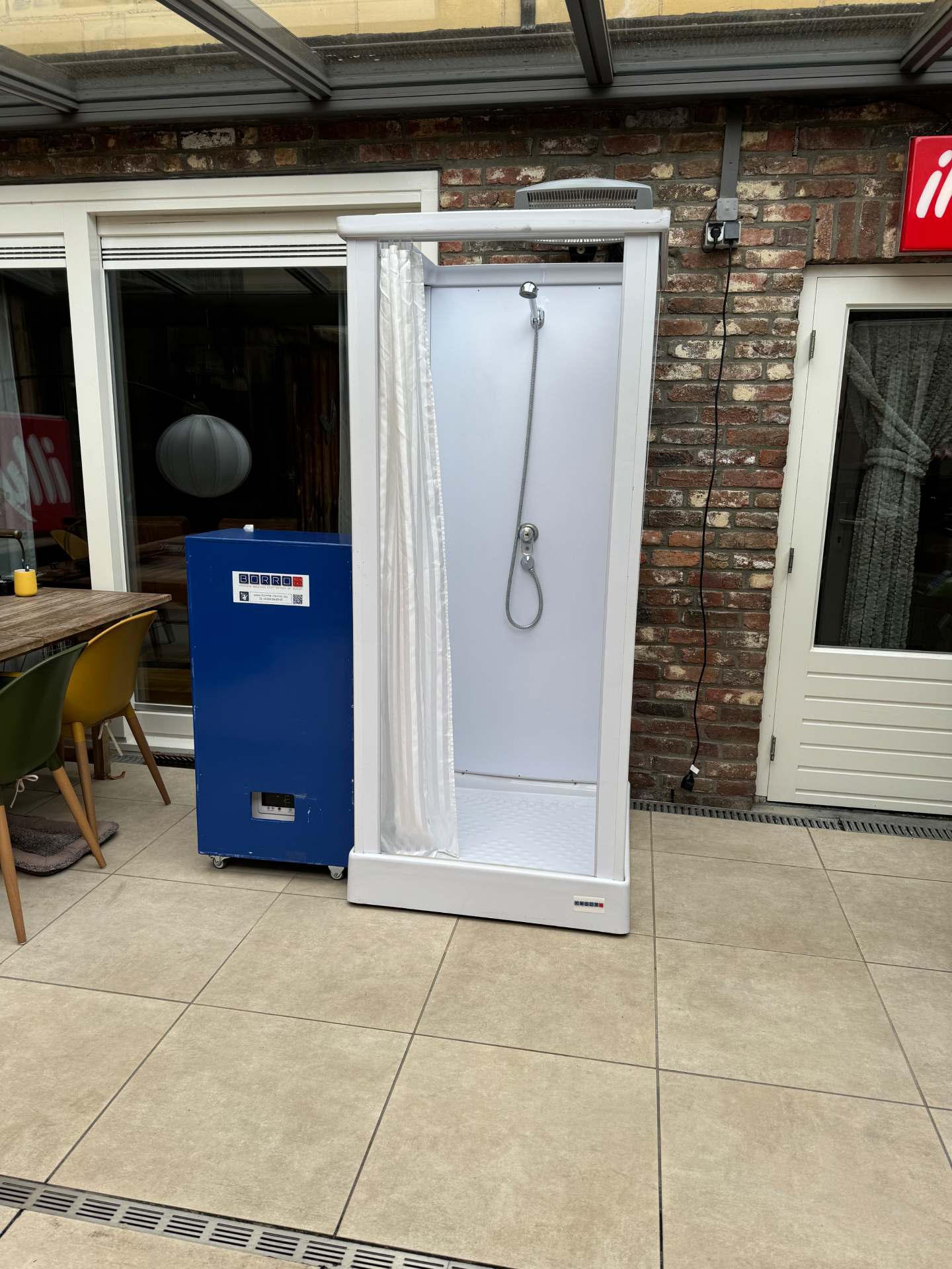 Mobile shower cabin on a terrace during a renovation
