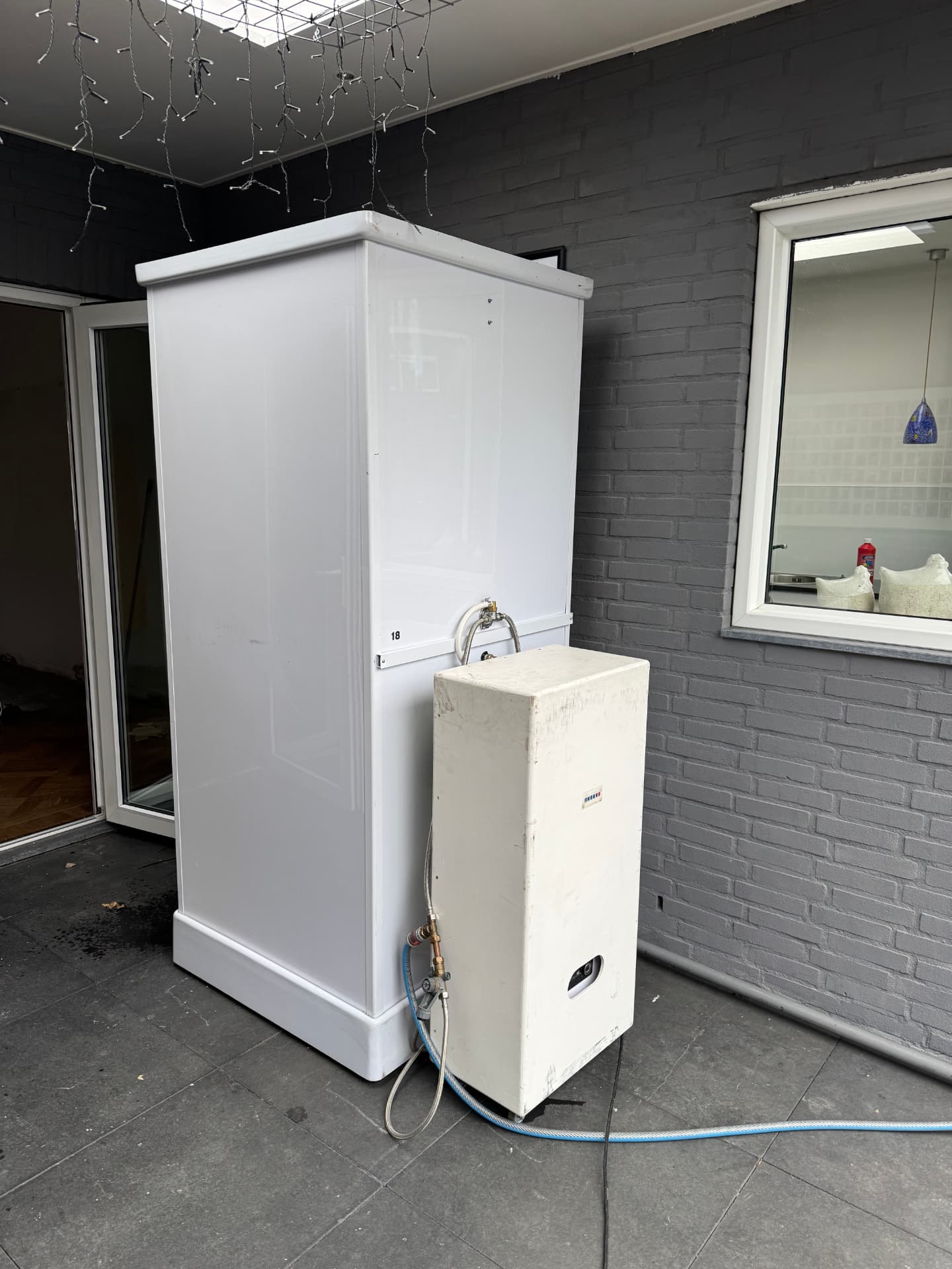 Mobiele douchecabine met mobiele boiler onder een overkapping