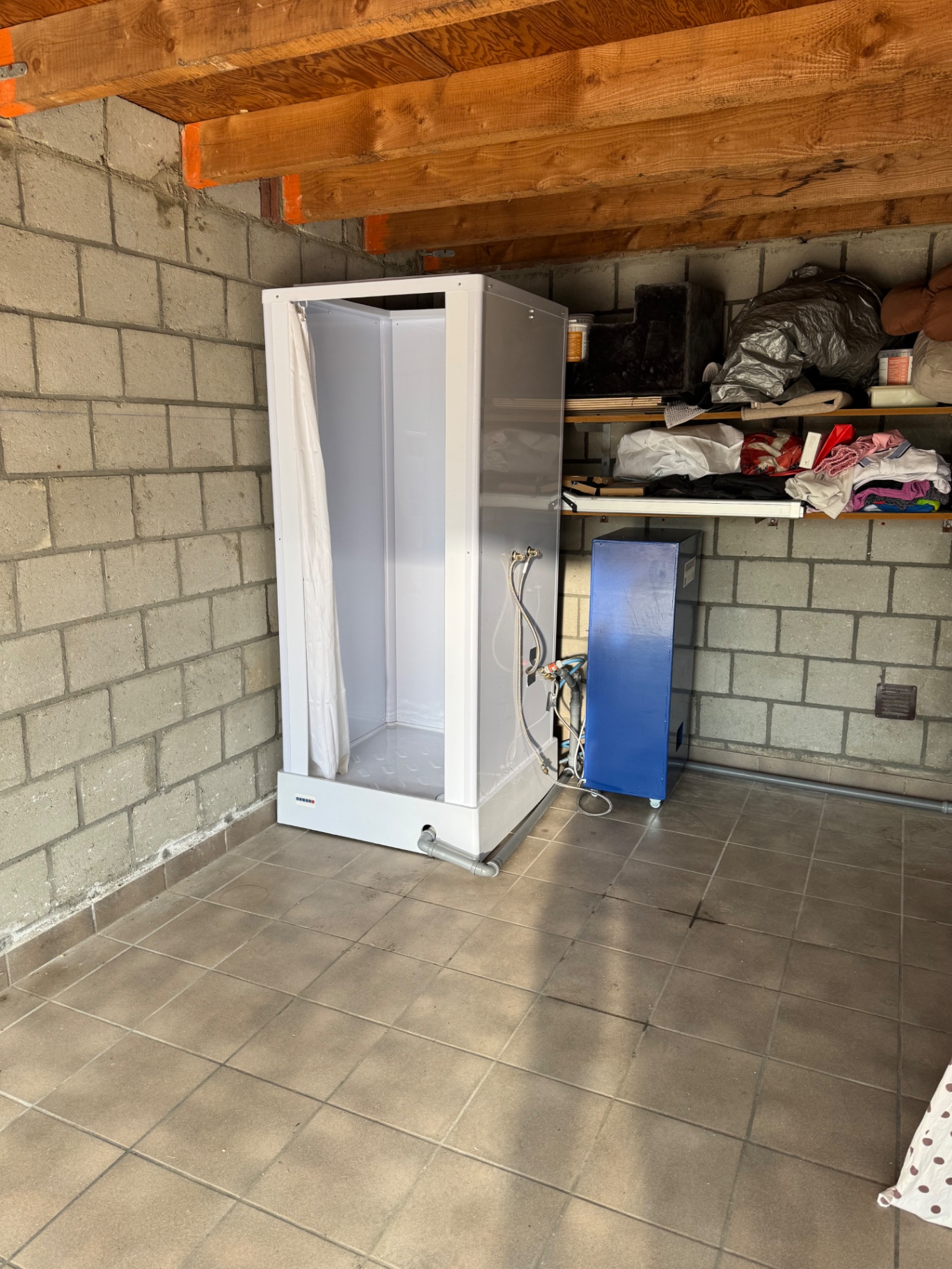 Indoor mobile shower cabin with water heater installed in a garage by Borro-Rental